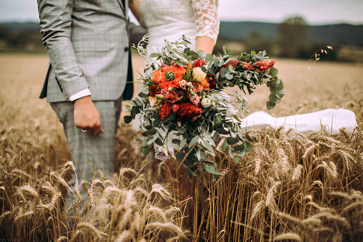 زوجان متزوجان حديثًا يحملان باقة زهور