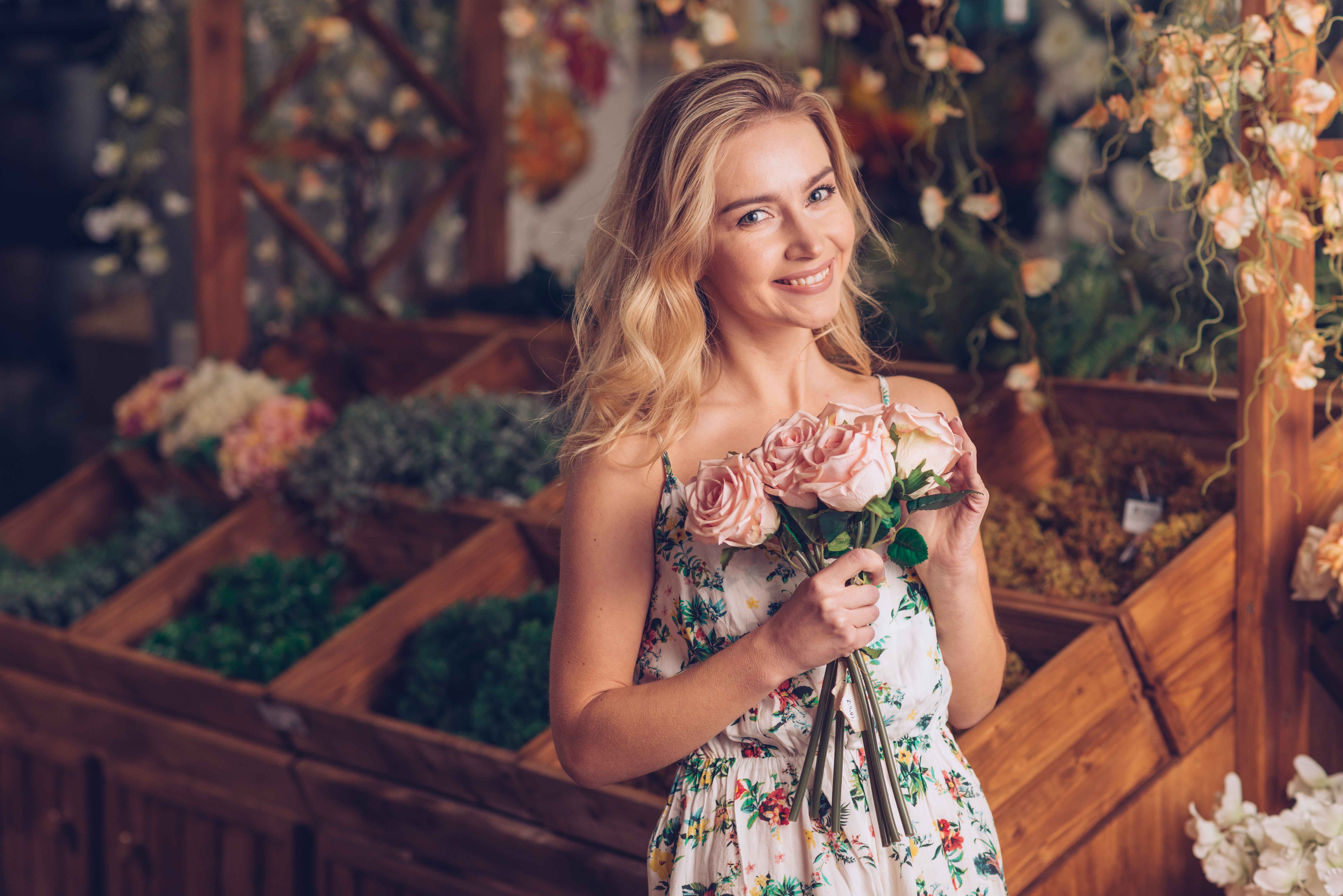 woman smiling holding pink roses